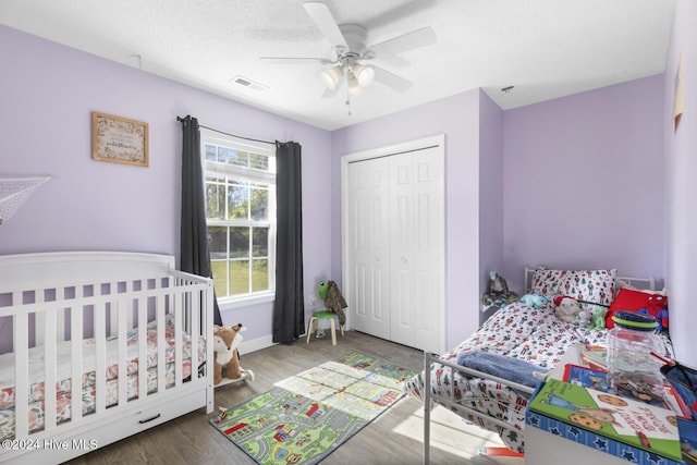 bedroom featuring wood-type flooring, a textured ceiling, a closet, and ceiling fan