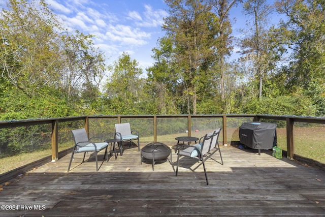 wooden deck featuring a fire pit and a grill