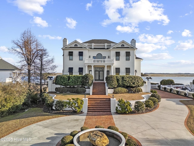 view of front of house with a balcony and a water view