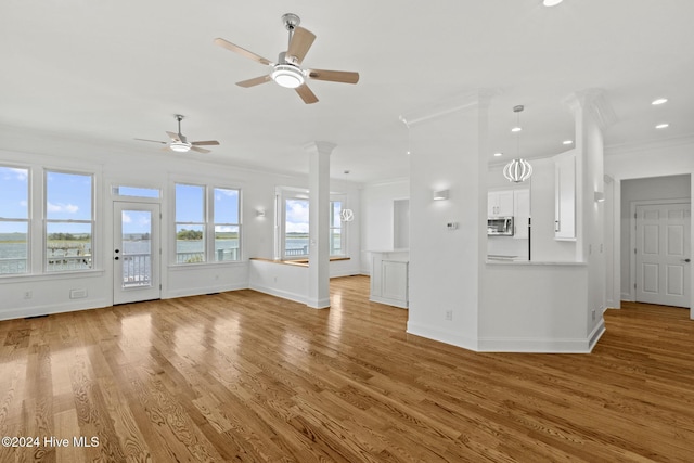 unfurnished living room featuring light wood-type flooring, ceiling fan, ornamental molding, and ornate columns