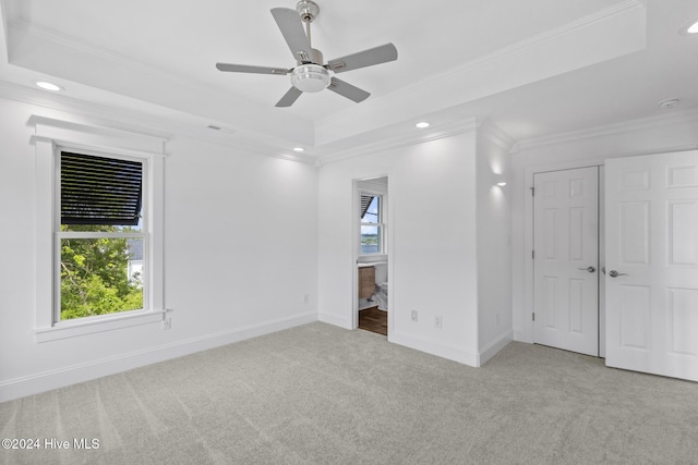 unfurnished bedroom with ceiling fan, light carpet, a closet, and a raised ceiling