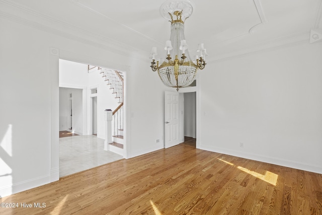 unfurnished dining area featuring an inviting chandelier, ornamental molding, and hardwood / wood-style flooring