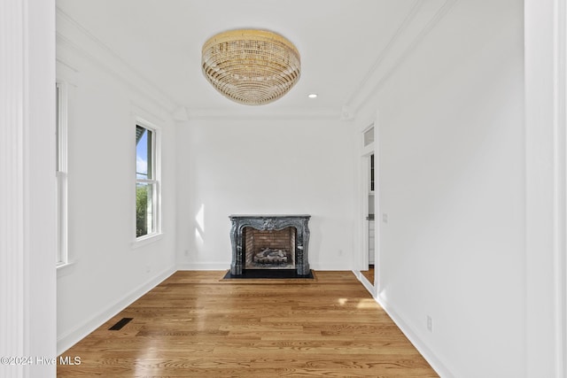 unfurnished living room featuring ornamental molding and hardwood / wood-style flooring