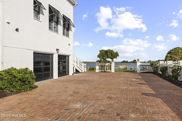 view of yard featuring a water view and a garage