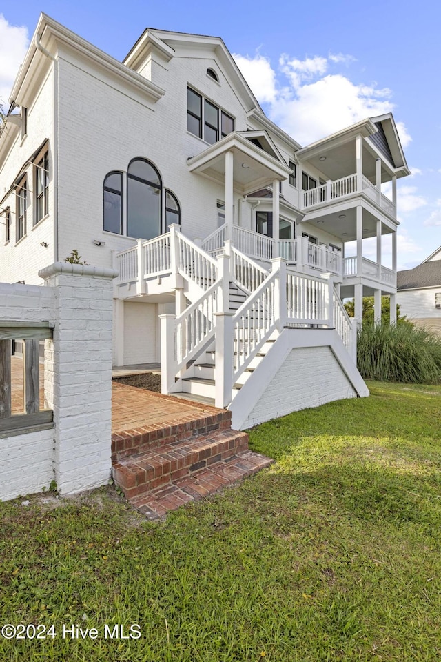 back of property with a balcony and a yard