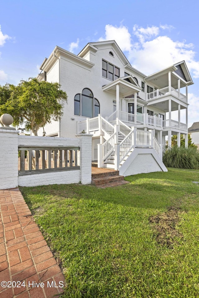 view of front of property featuring a front lawn and a balcony