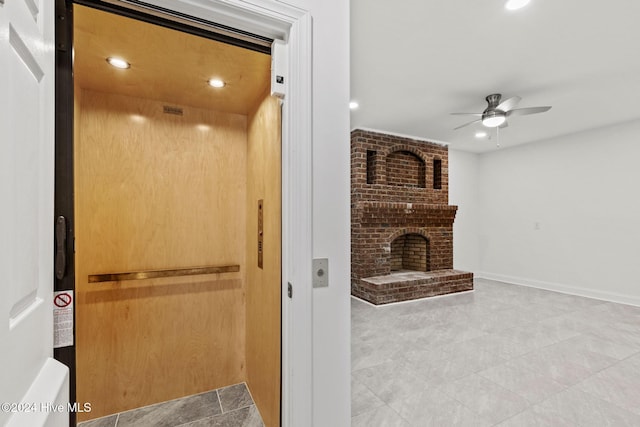 bathroom featuring ceiling fan, elevator, and a brick fireplace