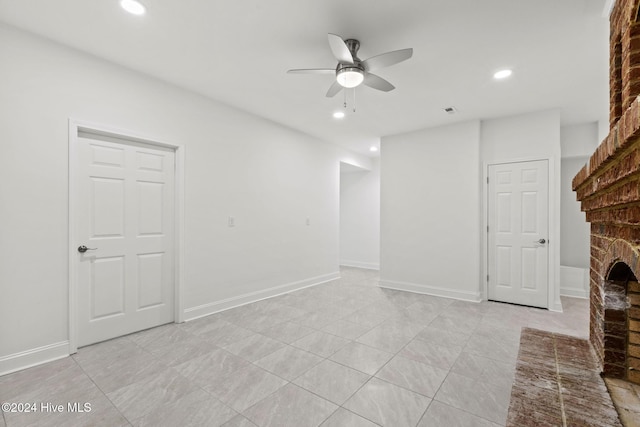 unfurnished living room featuring a brick fireplace and ceiling fan