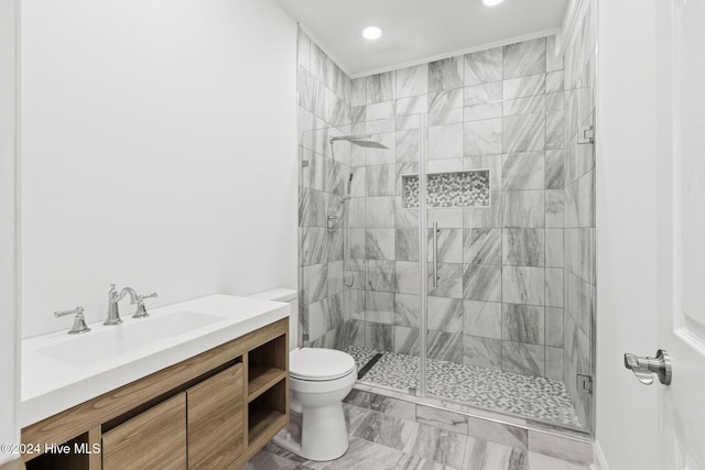 bathroom featuring a shower with shower door, toilet, and vanity