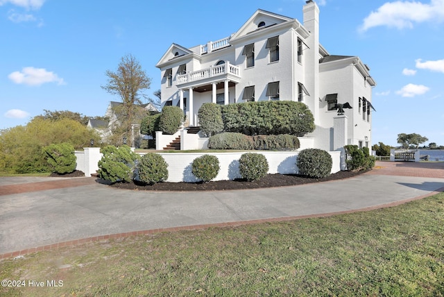 view of front of house featuring a front yard and a balcony