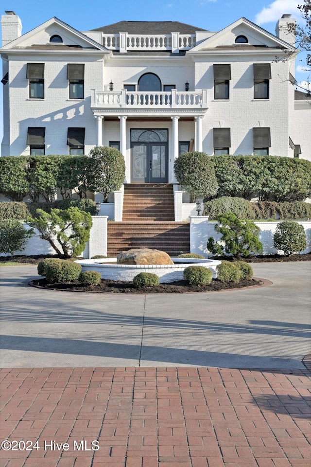 view of front of property with french doors and a balcony