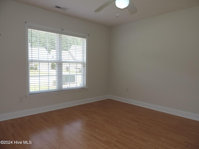 unfurnished room with ceiling fan, wood-type flooring, and a wealth of natural light