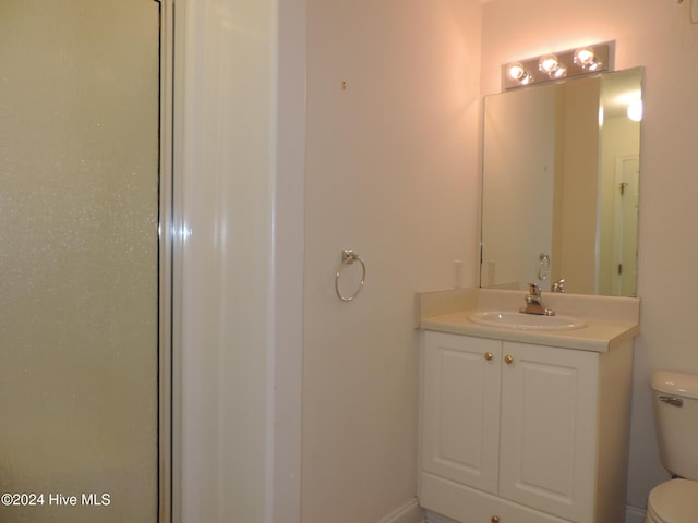 bathroom featuring vanity, toilet, and walk in shower