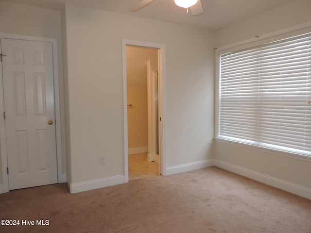 unfurnished bedroom featuring ceiling fan and light colored carpet