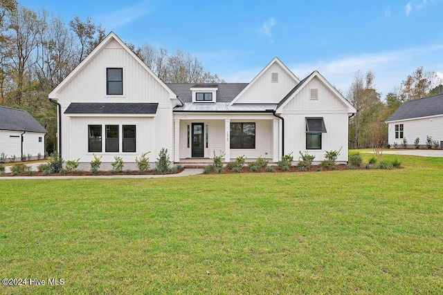 modern farmhouse style home featuring covered porch and a front yard