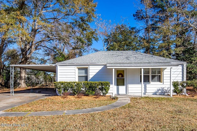 view of front of property with a carport, a porch, and a front yard