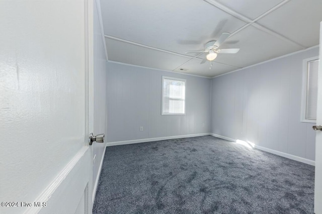 unfurnished room featuring ceiling fan, crown molding, and dark carpet