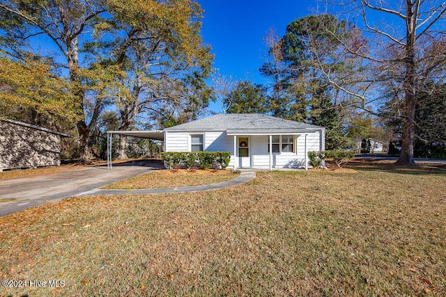 view of front of property featuring a front lawn, covered porch, and a carport