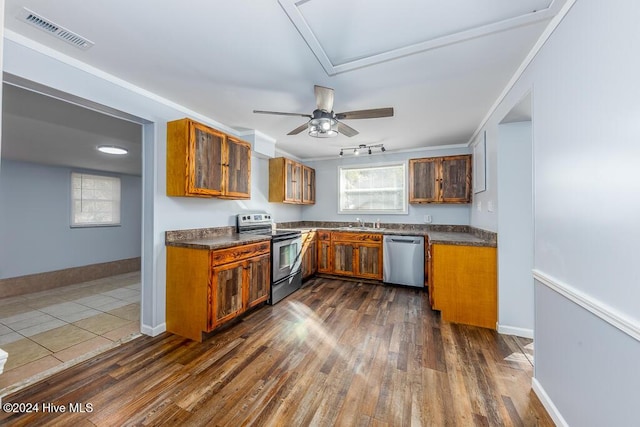 kitchen with appliances with stainless steel finishes, ornamental molding, ceiling fan, sink, and dark hardwood / wood-style floors