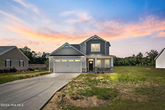 craftsman-style home featuring a garage and a lawn