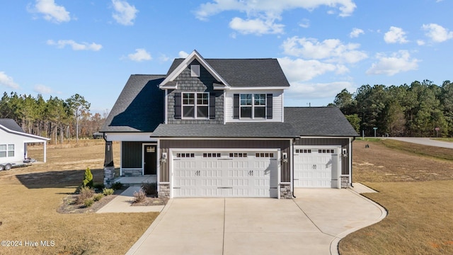 view of front facade with driveway, stone siding, a shingled roof, and a front lawn