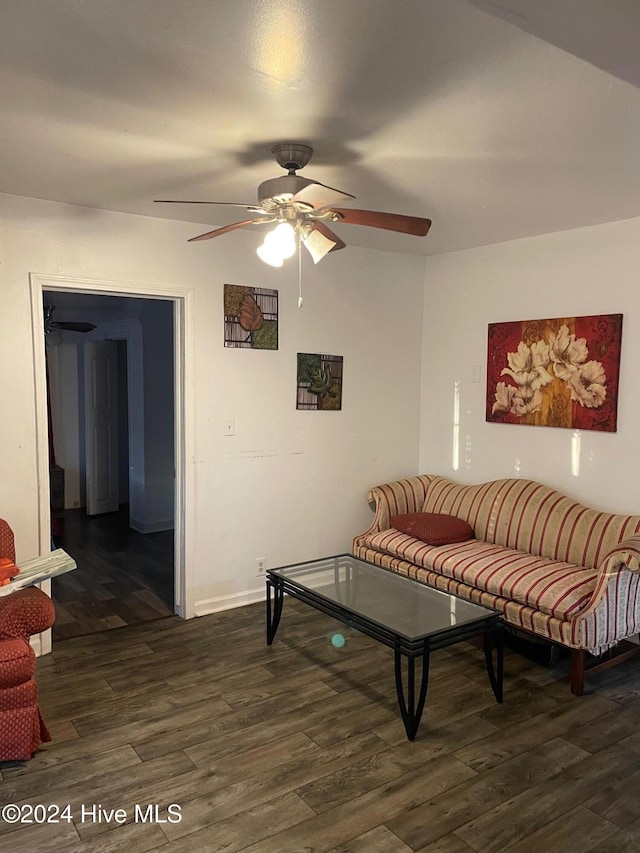 living room featuring ceiling fan and dark hardwood / wood-style floors