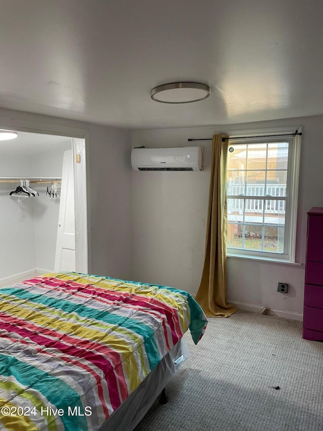 carpeted bedroom with a closet and a wall mounted AC