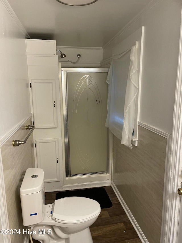 bathroom featuring wood-type flooring, an enclosed shower, toilet, tile walls, and ornamental molding