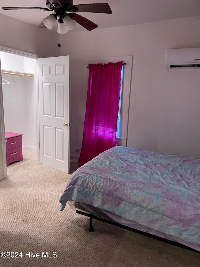 bedroom with a wall mounted AC, ceiling fan, and carpet floors