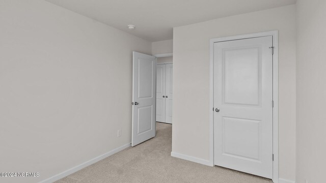 unfurnished bedroom with light colored carpet