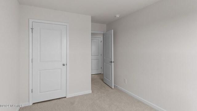 unfurnished bedroom featuring light carpet