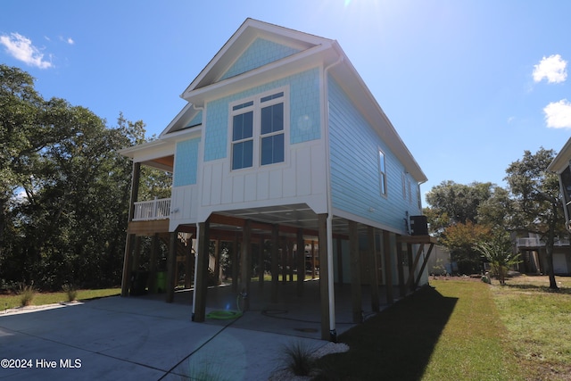 view of front facade with a front lawn, a carport, and central air condition unit