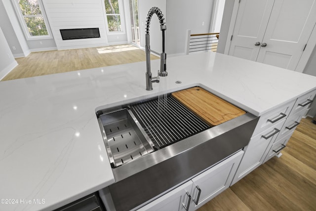 kitchen featuring white cabinetry, stainless steel range, wall chimney exhaust hood, and plenty of natural light