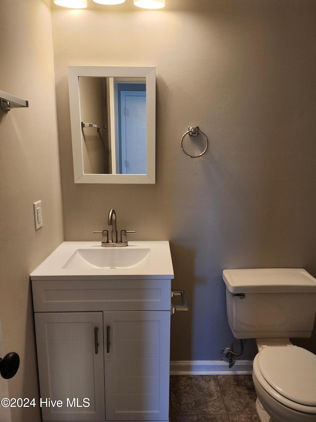 bathroom featuring toilet, vanity, and tile patterned floors