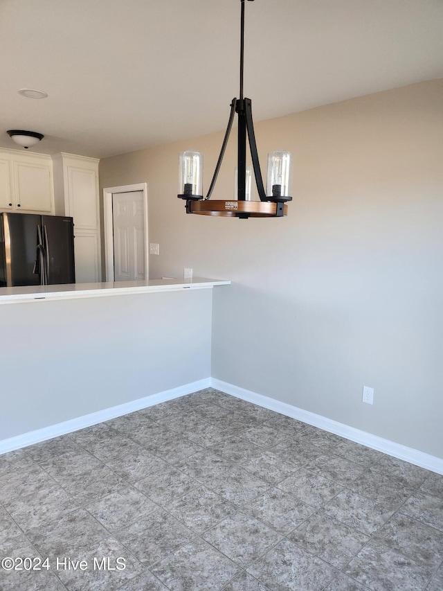 unfurnished dining area featuring an inviting chandelier