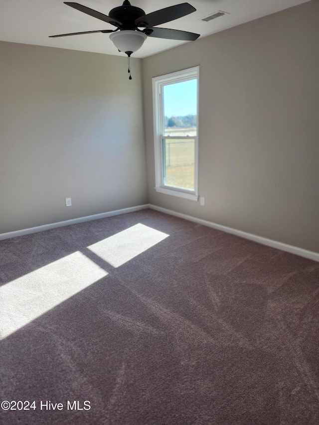 unfurnished room with ceiling fan and carpet