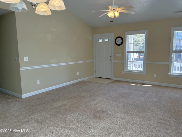 foyer with light carpet, vaulted ceiling, and ceiling fan