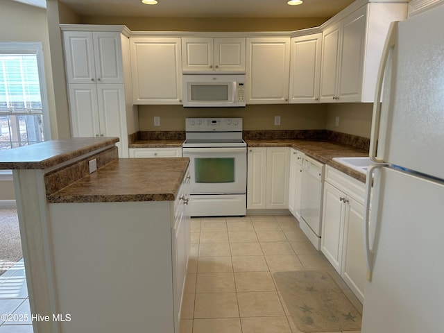 kitchen featuring white cabinetry, white appliances, a kitchen island, and light tile patterned floors