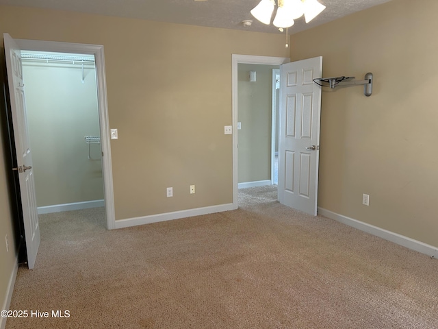 unfurnished bedroom with light colored carpet, a closet, and a textured ceiling