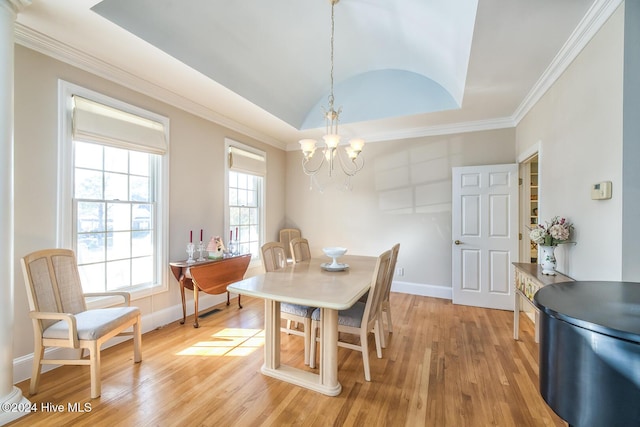 dining room featuring light hardwood / wood-style flooring, an inviting chandelier, lofted ceiling, and ornamental molding