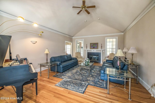 living room with hardwood / wood-style flooring, ceiling fan, ornamental molding, and vaulted ceiling