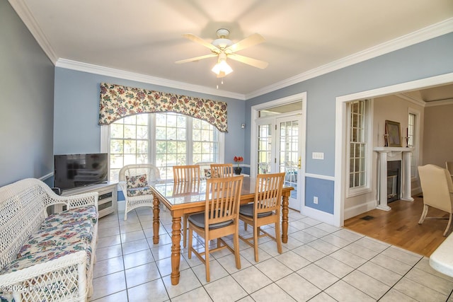 tiled dining room with crown molding and ceiling fan