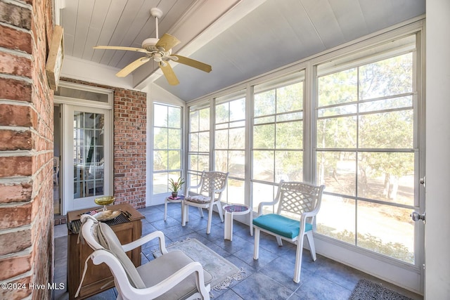 sunroom / solarium with lofted ceiling, wooden ceiling, and ceiling fan