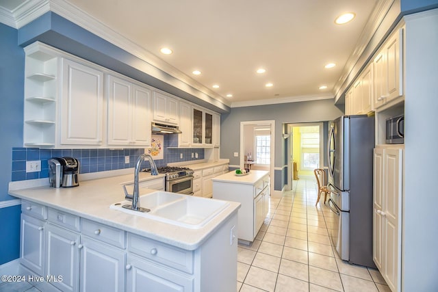 kitchen with crown molding, appliances with stainless steel finishes, white cabinets, light tile patterned flooring, and kitchen peninsula