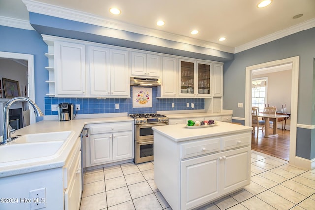 kitchen with light tile patterned flooring, white cabinets, stainless steel appliances, and ornamental molding