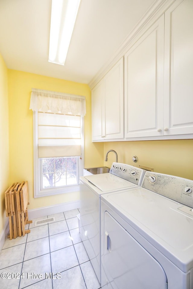 washroom with cabinets, separate washer and dryer, and light tile patterned floors