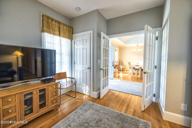 interior space with a chandelier, french doors, and wood-type flooring