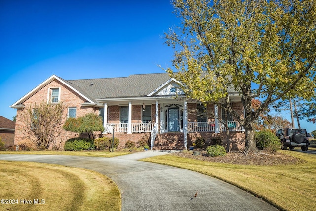 view of front of house with covered porch and a front lawn