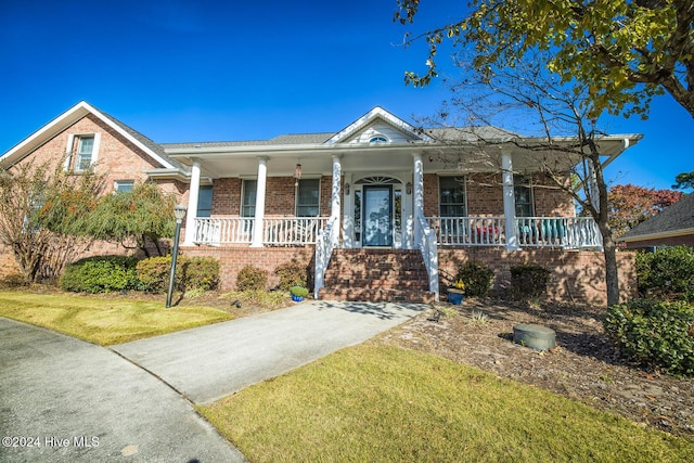 view of front facade with covered porch and a front lawn