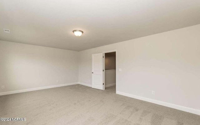 unfurnished room featuring light carpet